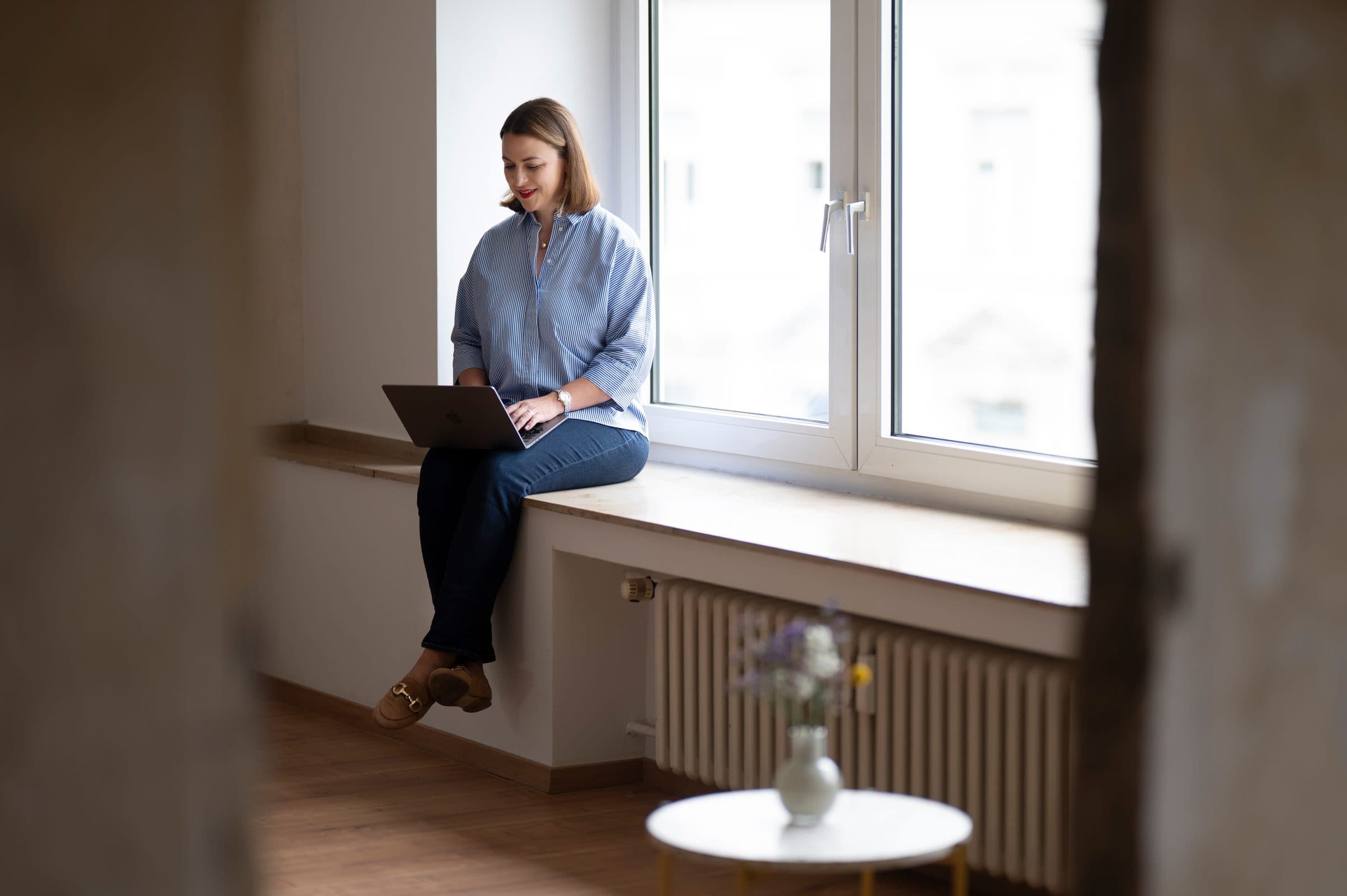 Victoria Beckers von Energie durch Entwicklung telefoniert und hält eine Kaffeetasse in der Hand – Momentaufnahme durch eine Glasscheibe, die Fokus und Ruhe vermittelt. Victoria Beckers von Energie durch Entwicklung telefoniert und hält eine Kaffeetasse in der Hand – Momentaufnahme durch eine Glasscheibe, die Fokus und Ruhe vermittelt.